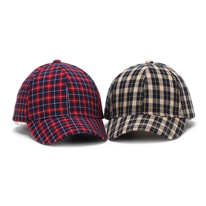 Detail view of two plaid baseball caps featuring classic woven textile patterns and textures