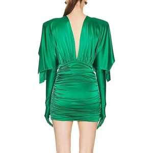 Dettaglio dell'abito in raso verde con texture a pieghe ed elegante scollo a V sulla schiena