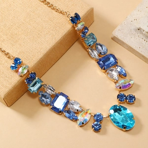 Macro view of crystal necklace with blue and clear multi-shaped gemstones in gold setting