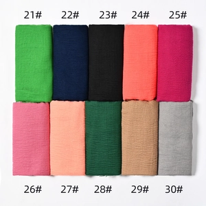 Flat lay of crinkled cotton scarves in various colors with numbered labels from 21 to 30