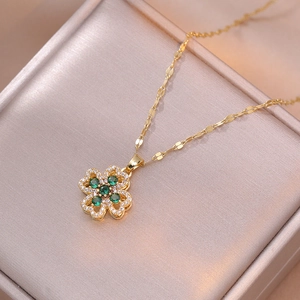 Vue macro du pendentif trèfle doré avec pierres vertes et cristaux scintillants