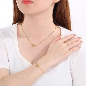Golden knot jewelry set with necklace, bracelet, earrings and ring on model
