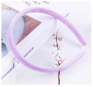 Detailed close-up of a purple plush fabric headband styled with natural cotton decor