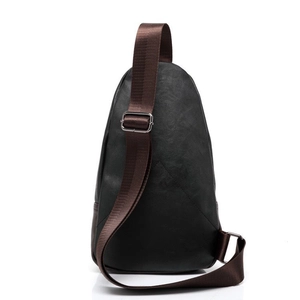 Detail view of the black PU leather crossbody bag featuring a textured finish and brown strap