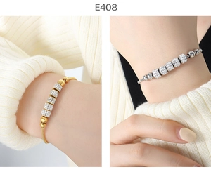 Close-up of gold and silver snake chain bracelets with sparkling pavé cylinder beads