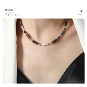 Detailed view of handmade necklace featuring freshwater pearls and natural stones on a model