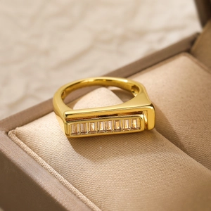 Macro shot of gold plated copper ring with a row of rectangular zircon stones