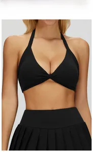 Macro shot of black yoga top with halter twist knot and pleated sport skirt details