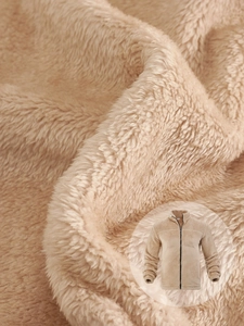 Detailed macro view of beige polar fleece texture and stand collar zipper jacket