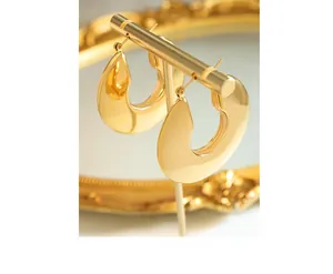 Detailed close-up of chunky gold-plated U-shaped hoop earrings on a display stand