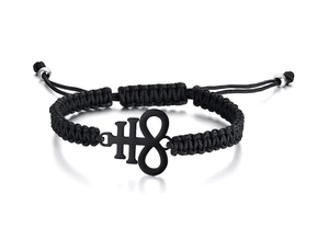 Detail of black woven bracelet featuring a silver Leviathan cross metal charm on white background
