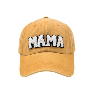 Detailed close-up of MAMA towel embroidery on washed vintage yellow cotton baseball cap