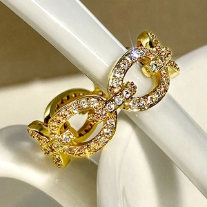 Macro shot of interlocking pavé-set gold rings with clear zircons for a stylish geometric look