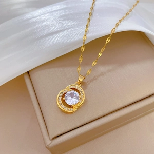 Elegant gold double circle necklace with large zircon pendant on beige jewelry box