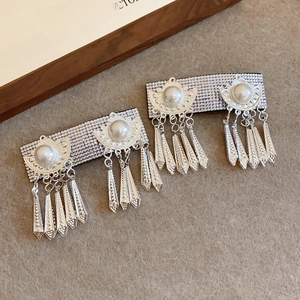 Detail view of vintage silver earrings with pearls, rhinestones and tassel pendants