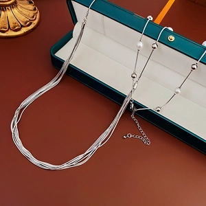 Detail of silver multi-layer necklace with pearls displayed in a green jewelry gift box