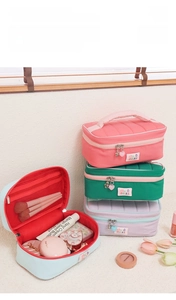 Detail of cute quilted makeup bags in pastel colors with heart zipper charms