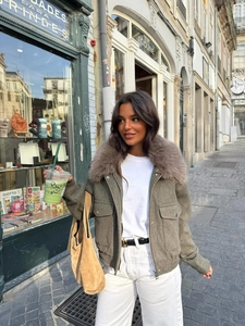 Detail of olive green jacket featuring a large faux fur collar and utility pockets