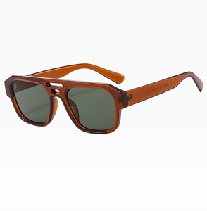 Detail view of tea-colored transparent frames and dark green lenses of the flat top sunglasses