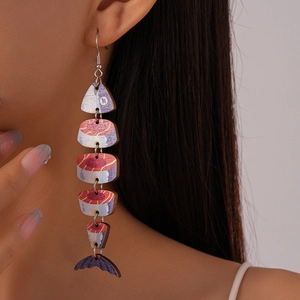 Detail showing creative fishbone drop earrings with wood grain texture worn by a model