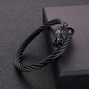 Détail d'un bracelet tête de dragon punk noir avec un design de câble en fil d'acier