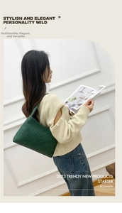 Close-up of emerald green woven leather texture on a stylish crescent shoulder bag