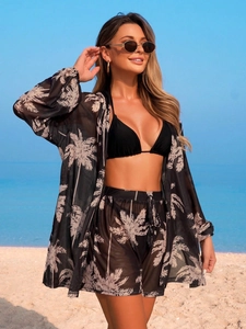 Ensemble de plage 3 pièces avec bikini noir et paréo imprimé palmier sur une plage ensoleillée