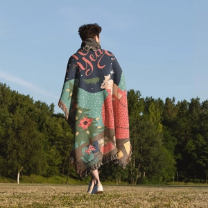 Outdoor lifestyle shot of a woven Christmas tree blanket with tassels on green grass
