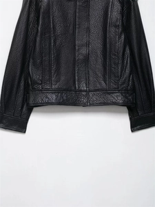 Nahaufnahme der schwarzen PU-Lederjacke mit Lychee-Struktur und Saumstickerei-Details