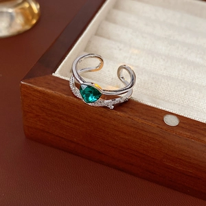Bague en argent avec pierre verte en cœur dans un écrin de luxe en velours et bois