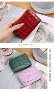 Detail showing crocodile texture pattern and gold zippers on compact leather card cases