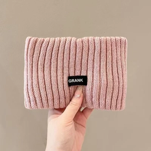 Close-up of pink knitted headband with rib texture and black woven GRANK label