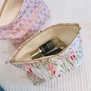 Detail of floral jacquard embroidery and metal zipper on high-capacity makeup bag