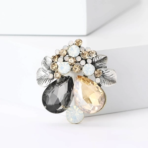 Detailed macro view of vintage silver floral brooch with champagne and grey rhinestones