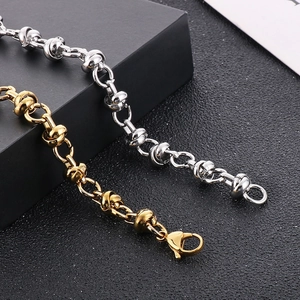 Macro detail of industrial knot chain links in gold and silver finish with lobster clasp