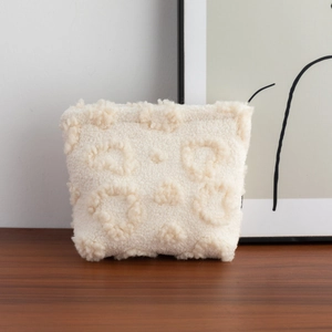 Detail of soft white plush storage bag featuring a textured circular tufted pattern