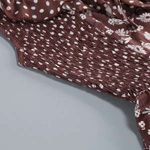 Detail of smocked brown dress featuring vintage daisy and polka dot pattern fabric