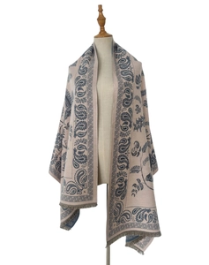 Detail of soft beige scarf with blue paisley pattern and elegant fringe edges