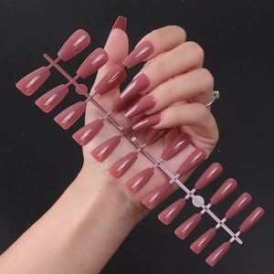 Macro view of long ballerina-shaped press-on nails with glossy UV finish in mauve pink