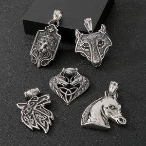Macro detail of vintage silver steel lion, wolf, and horse pendants on black texture