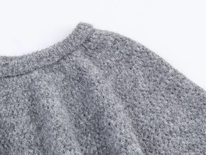 Détail macro du col rond en maille ajourée grise avec texture douce et moelleuse