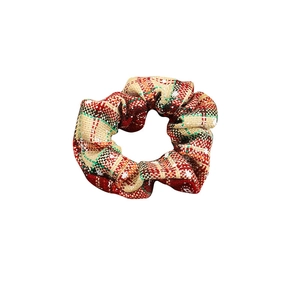 Christmas scrunchie with red and green snowflake plaid fabric on a white background