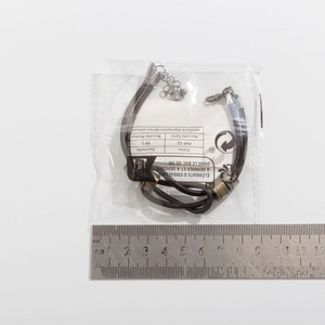 Detailed view of leather knotted beaded necklace with ruler measurement on white background