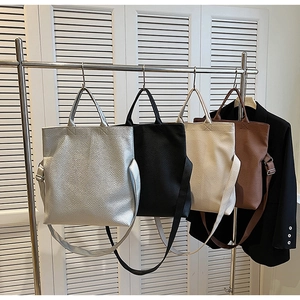 Große Tragetaschen mit Litschitextur in Silber, Schwarz, Beige und Braun im Detail gezeigt