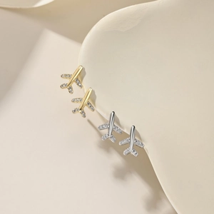Detailed close-up of S925 silver airplane earrings in gold and silver with zircon stones