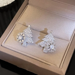 Rotating Christmas tree stud earrings with zircon and silver pins in a jewelry box