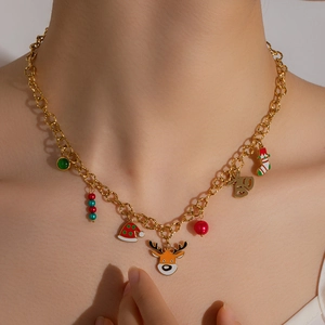 Close-up of gold Christmas necklace featuring reindeer, Santa hat, and bell charms on model