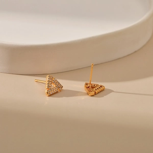 Detailed view of triangular gold-plated stud earrings with pavé set white zircon crystals