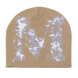 Détail du bonnet en maille kaki avec motif M blanc pixélisé et texture de tricot côtelé