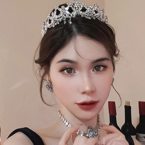 Close-up of luxury bridal jewelry set with rhinestone crown, necklace, and earrings